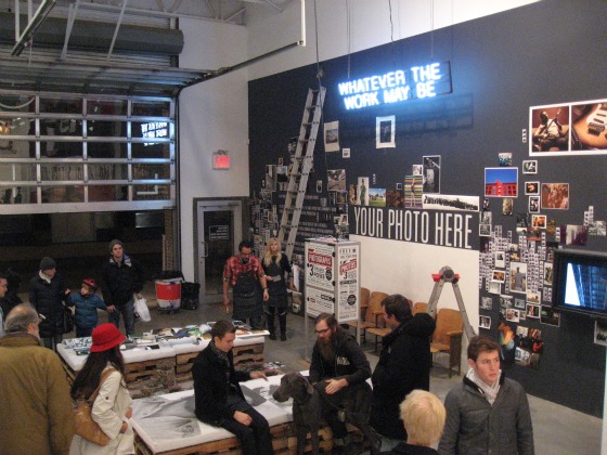 Levi's Photo Workshop students gather around work stations, a background of photos on wall