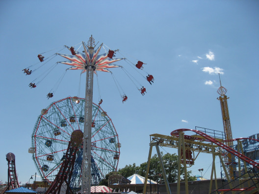 Coney Island amusement park spining ride, ferris wheel, and roller coaster