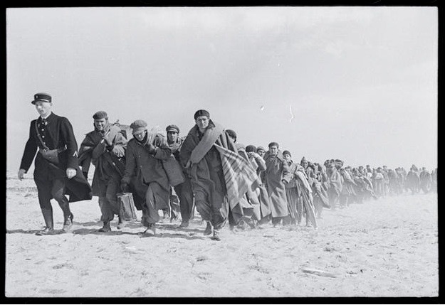 Black and White photograph of men marching through the dessert in Mexican Suitcase at the International Museum of Photography in NYC