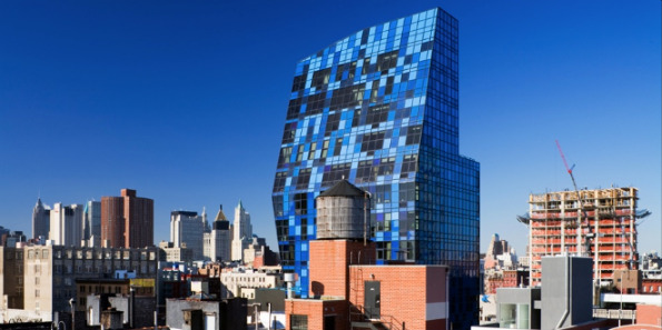 The Blue NYC building has various blue windows that reflect and blend with the sky