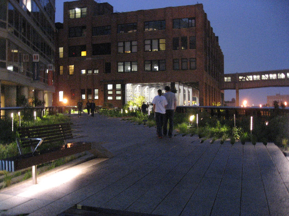 The High Line New York City building at night is a sweeping structure with a walkway bridge and pathway