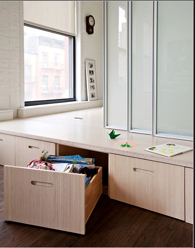 Light wood draws underneath a platform bed make for a perfect small apartment storage solutions 