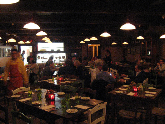 Interior of Osteria Morini in NYC rustic Italian decorations, wood tables and chairs, subdued lighting