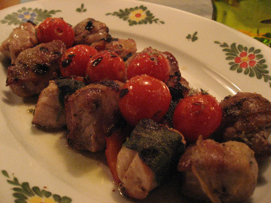 Chef Michael White serves up skewers of sweetbreads wrapped in sage with peppers and onions on a Italian style plate with flower accents