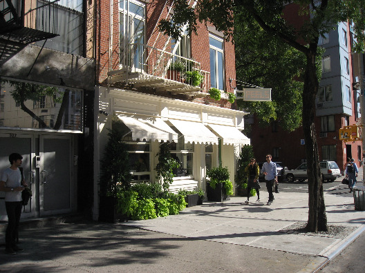 Peels restaurant in NYC street view brick exteriors with white awning and balcony