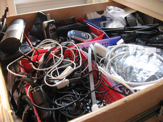 Drawer full of various electronic cords and devices, perfect for recycling 