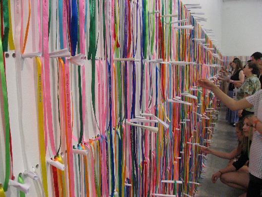 The New Museum wall adorned with colorful ribbons with messages that viewers can pull off and wear