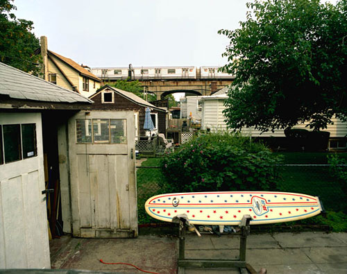 Exterior of a garage and surf board on a stand photograph at the Bonni Benrubi Gallery NYC