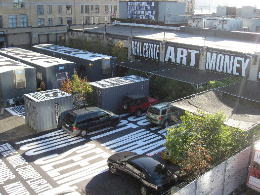 Public art in NYC by Babara Kruger featuring giant text reading real estate, art, money all posted on building at the site of the new whitney museum