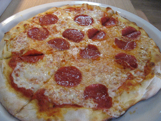 Vapiano pizza with pepperoni a full pie on a white plate