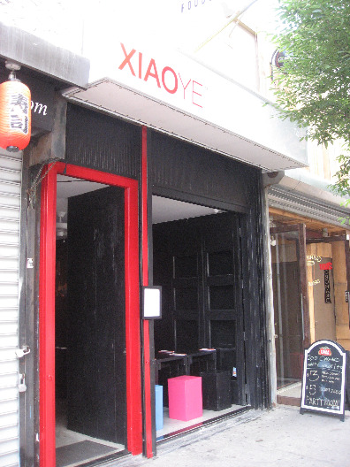 Xiao Ye NYC restaurant from the outside painted black with red trim and open to the street design